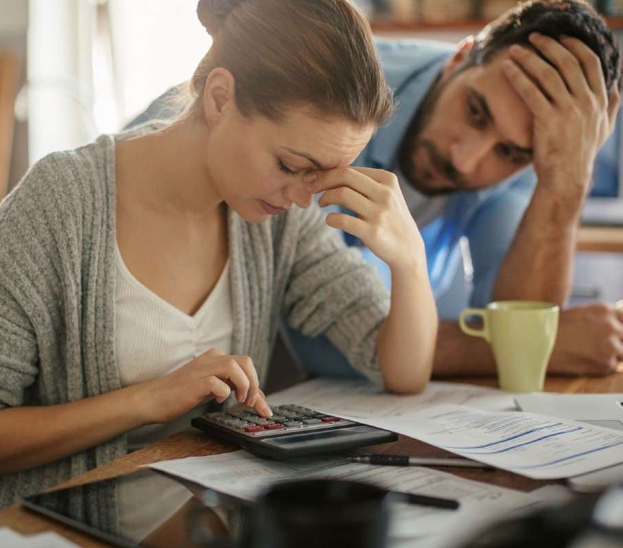 A stressed couple looking over financial documents
