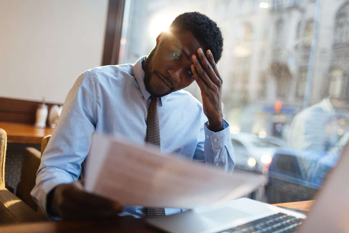 Stressed man at computer dealing with IRS Tax Problems