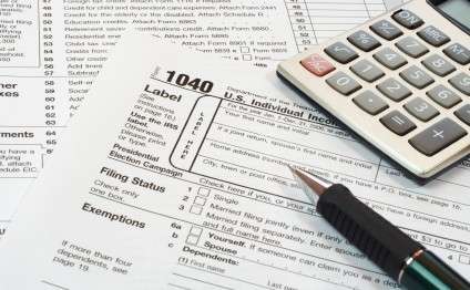 Tax return forms and a calculator on a desk.